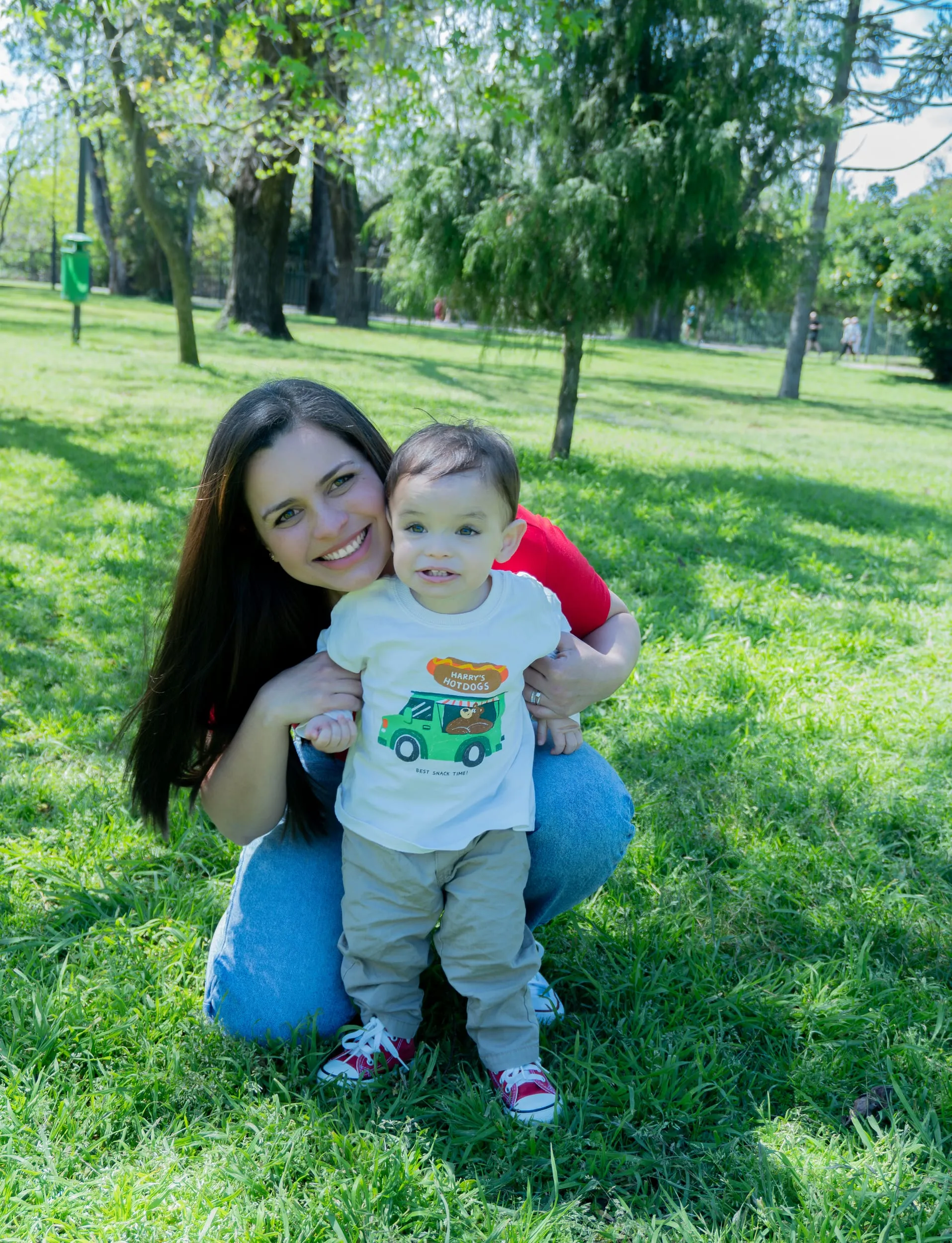 Mamá sonriendo con su bebé en una sesión de fotos al aire libre de LUX Visual